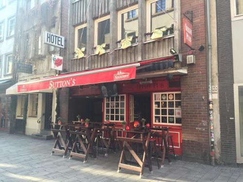 a restaurant with wooden tables outside of a building at Barcelona Bed & Breakfast in Düsseldorf