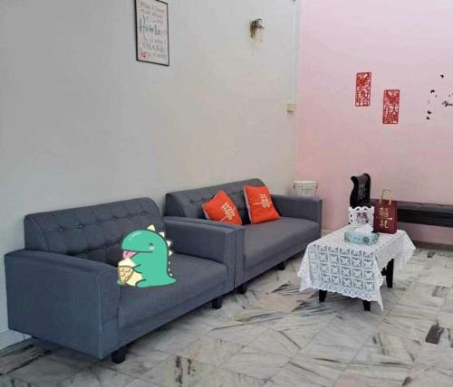a living room with a blue couch and a table at HAPPY HOMESTAY Lukut NS in Port Dickson