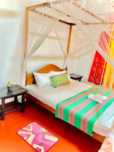 a bedroom with a bed with a canopy at Villa 277 - Mirissa in Bandaramulla