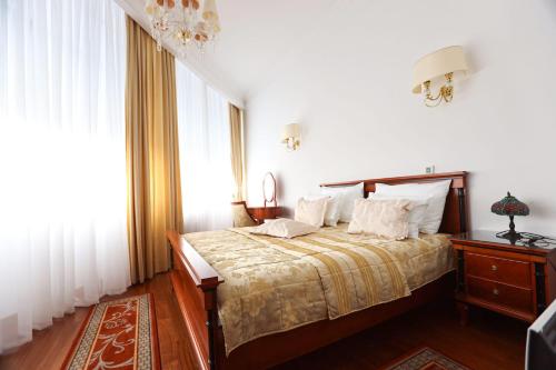 a bedroom with a bed with white walls and a window at Apart-hotel Integra in Banja Luka