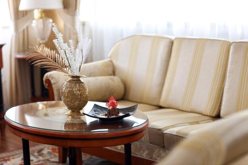 a living room with a couch and a table with a vase at Apart-hotel Integra in Banja Luka
