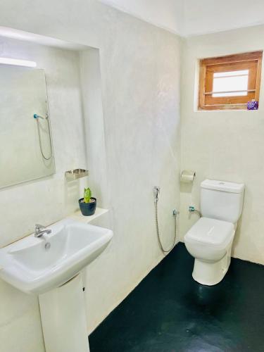 a bathroom with a white toilet and a sink at Villa 277 - Mirissa in Bandaramulla