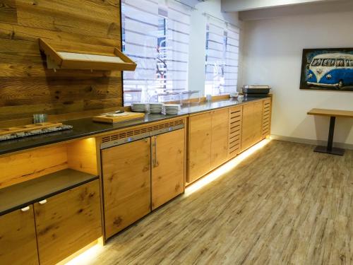a kitchen with wooden cabinets and a large window at Hotel Viva Bröckel in Bröckel