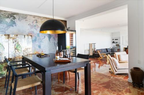 a dining room with a table and a living room at Casa Zen Pool and Views in Cabrils