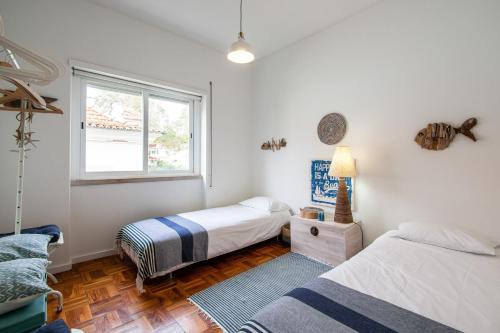 une chambre avec deux lits et une fenêtre dans l'établissement Elegant Apartment in Cascais with Fireplace - 80 m², à Cascais