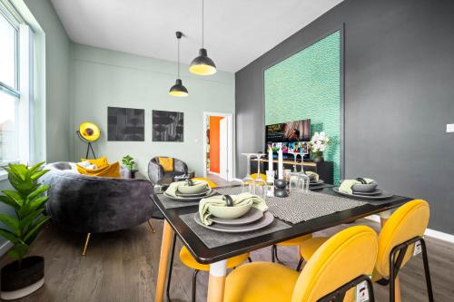 a dining room with a table and yellow chairs at Spacious Stylish Apartment - City Centre - Secure Parking - 1SH in Birmingham