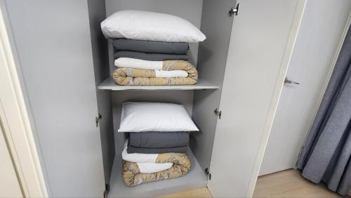 a walk in closet with towels and pillows at Haeundae Bada Stay in Busan