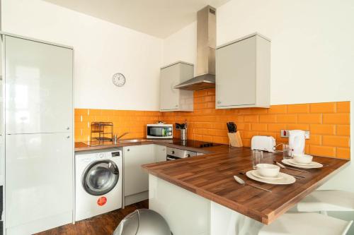 a kitchen with a wooden counter top and a washing machine at Fabulous 1 Bed Apartment in Central Blackburn in Blackburn