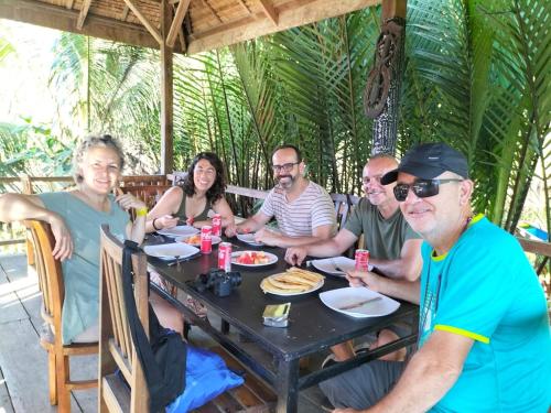 a group of people sitting at a table eating food at Rammang Rammang Ecolodge and Cafe in Kasijala