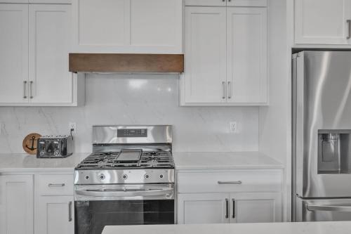 a white kitchen with a stove and white cabinets at Sunset Cove home in Oshkosh