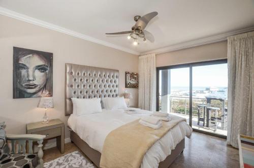 a bedroom with a large bed and a large window at Wave song in Yzerfontein