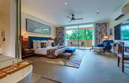 a hotel room with a bed and a living room at VILEEN Rishikesh - A Wellness Resort by Ganga Kinare in Bijni