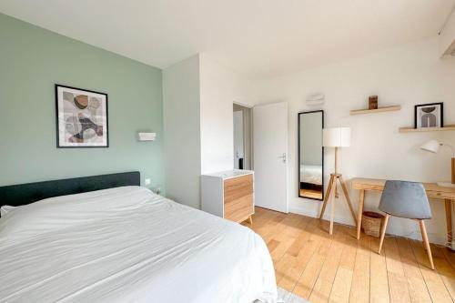 Un dormitorio blanco con una cama y un escritorio. en Flexliving - room - Ternes, en París