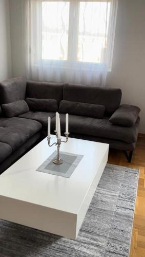 a living room with a couch and a table with candles at Apartment Shine in Konik