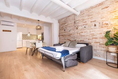 タラゴナにあるCavallers by Unik Vacationのベッドとレンガの壁がある寝室