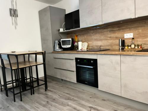 - une cuisine avec un comptoir et une cuisinière four supérieur dans l'établissement TI TAHITI STUDIO-3MIN PLAGE-TERRASSE COSY-WIFI-PARKING - TOP PROS SERVICESConciergerie La Grande Motte, à La Grande Motte