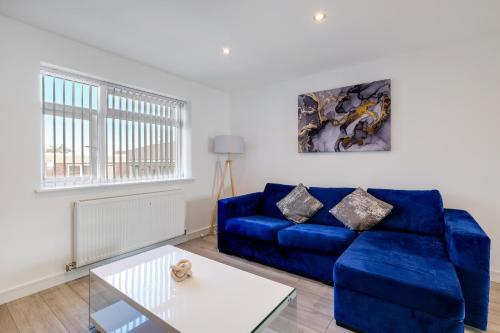 a living room with a blue couch and a table at St Martins 2 Bedroom Apartments in Ruislip By 360 Stays in Ruislip
