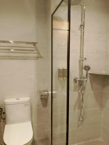 a bathroom with a toilet and a glass shower at Forum Hotel Penang in George Town