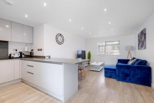 a kitchen and living room with a blue couch at St Martins 2 Bedroom Apartments in Ruislip By 360 Stays in Ruislip