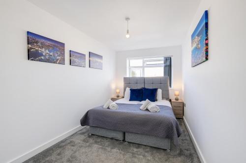 a bedroom with a king sized bed with blue pillows at St Martins 2 Bedroom Apartments in Ruislip By 360 Stays in Ruislip