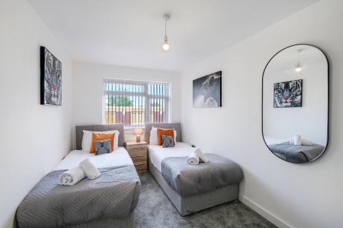 a white room with two beds and a mirror at St Martins 2 Bedroom Apartments in Ruislip By 360 Stays in Ruislip