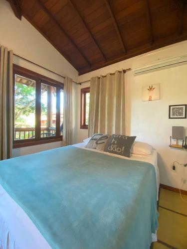 a bedroom with a blue bed with a window at Maui Suítes e Chalés in Arraial d'Ajuda