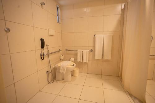 a bathroom with a toilet and a phone at Hilton Garden Inn Maceio in Maceió