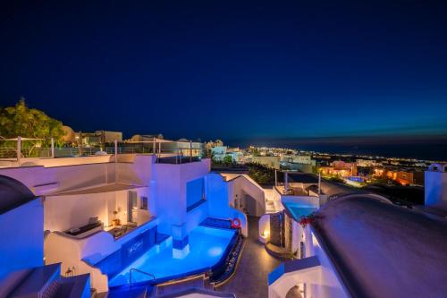 a night view of a building with a swimming pool at Sole d'oro Luxury Suites in Oia