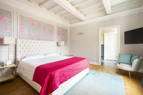 Un dormitorio con una cama grande y una silla. en Albizi Penthouse Luxury Apartment In Florence By Palazzo Pazzi Vitali, en Florencia