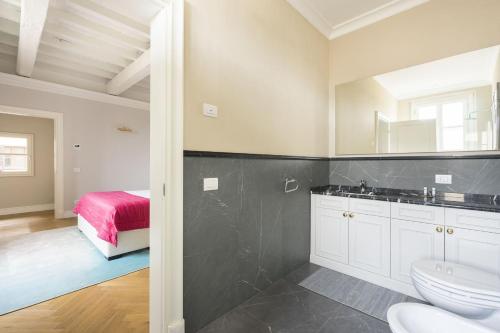 Un baño con inodoro, lavabo y cama. en Albizi Penthouse Luxury Apartment In Florence By Palazzo Pazzi Vitali, en Florencia