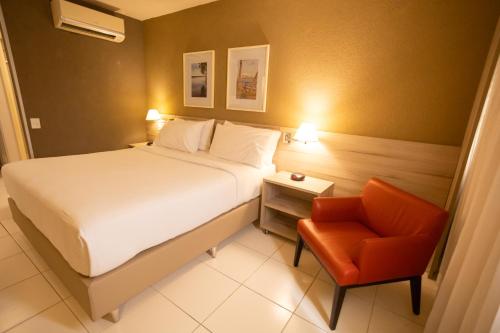 a hotel room with a bed and a chair at Hilton Garden Inn Maceio in Maceió