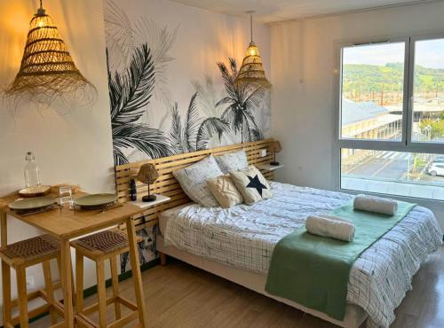 une chambre avec un lit, un bureau et une fenêtre dans l'établissement Oasis - Wifi, Clim, Vue, Équipé, à Lourdes