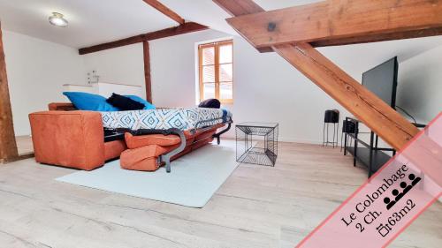 un salon avec un canapé et une télévision dans l'établissement Les Appartements Charme et Élégance, à Sainte-Croix-en-Plaine