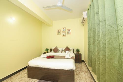 a bedroom with a bed and a ceiling fan at Margaritas Residency in Benaulim