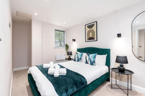 a bedroom with a large bed with a green headboard at Luxury One Bedroom Apartment - City Centre - Free Wifi Netflix in Leeds
