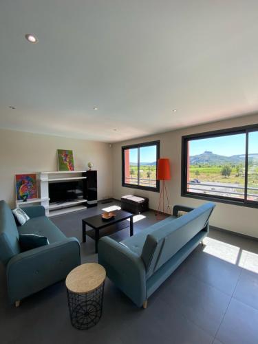 a living room with a couch and a table at Rev'ôthijol Vacances in Saint Alban Auriolles