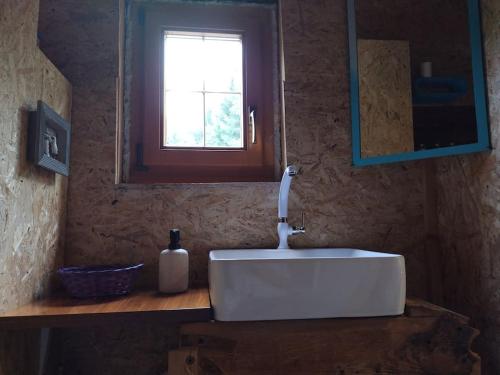 a white sink in a bathroom with a window at "Tiny Tenne" 15m2 im Altem Bergbauernhaus 1110m in Purbach
