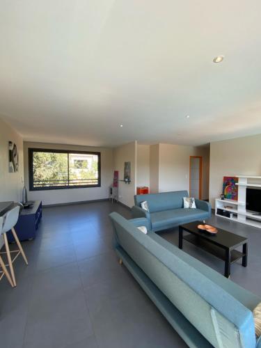 a living room with a blue couch and a table at Rev'ôthijol Vacances in Saint Alban Auriolles