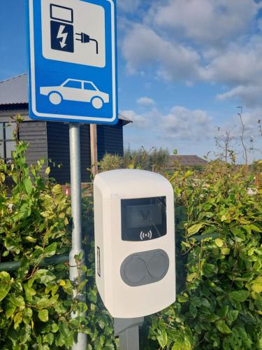 a parking meter with a car on it next to a sign at Boerderij Hazenveld in Kockengen