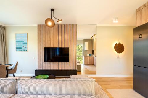 a living room with a couch and a tv at Nautica Resort in Giżycko
