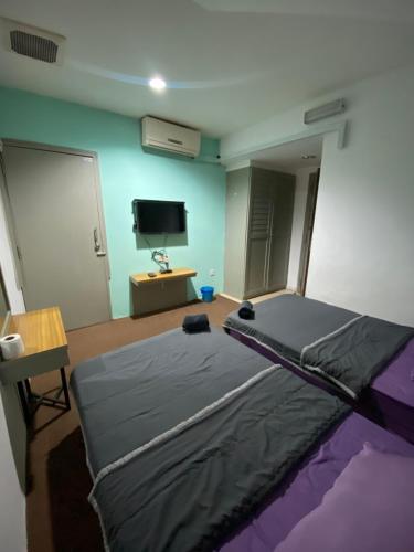 a bedroom with a bed and a flat screen tv at KB MYPLACE in Kota Bharu