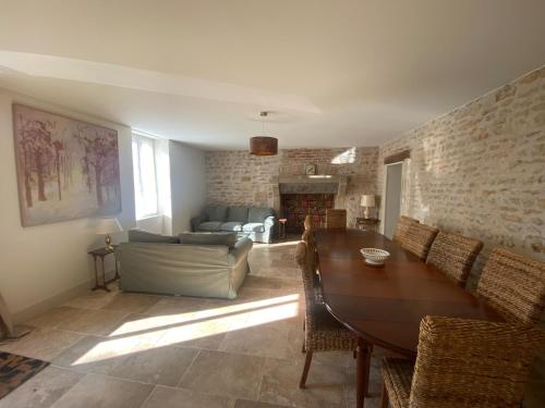una sala de estar con una mesa y un sofá en Grande maison avec super vue, en Saint-Benin-dʼAzy