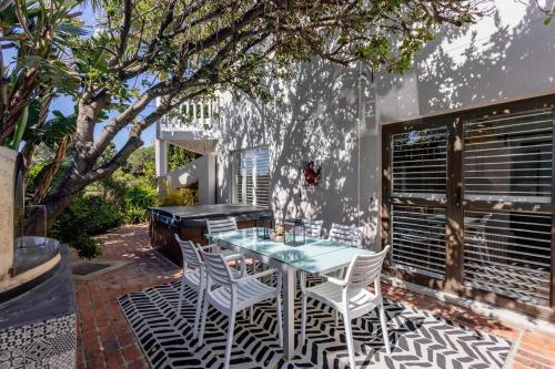 a patio with a table and chairs and a piano at Plett Holiday Stay with Hut Tub ,Pizza Oven and Views in Plettenberg Bay