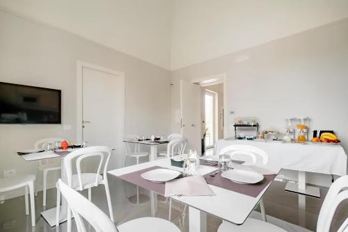 a white dining room with white tables and white chairs at Shoruq in Marsala