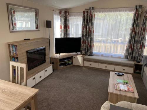 un soggiorno con TV a schermo piatto e ampia finestra di Rhodes Retreat, Lake District a Brigham