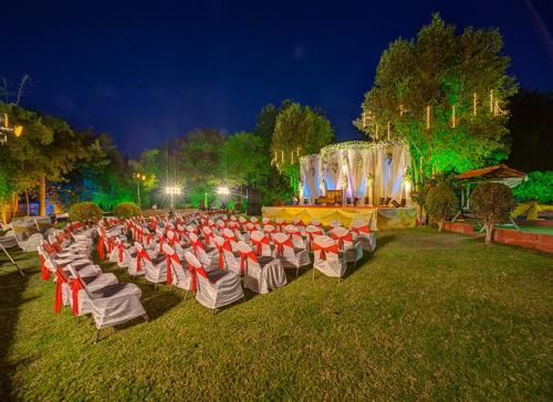 a group of chairs sitting in the grass at night at Renest Shraddha Inn - Shirdi in Shirdi