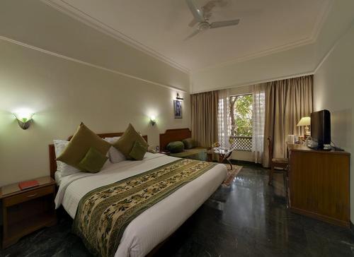 Habitación de hotel con cama grande y TV en Renest Shraddha Inn - Shirdi, en Shirdi