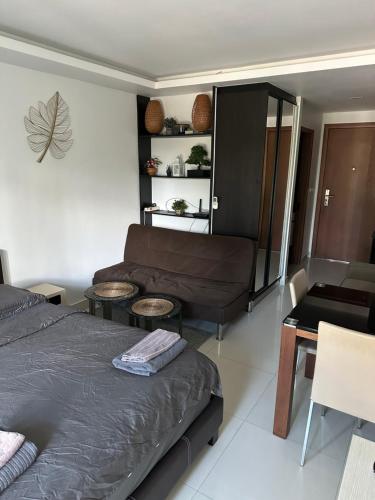 a bedroom with a bed and a couch and a table at Club Royal Apartments in Pattaya North