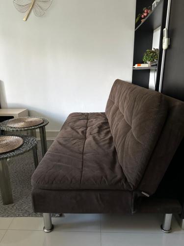 a brown couch sitting in a room with a table at Club Royal Apartments in Pattaya North