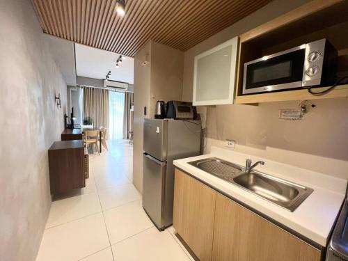 a kitchen with a sink and a stainless steel refrigerator at Miranda B 319 at Pico de Loro by Raquels Place in Nasugbu